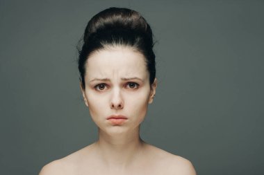 Çıplak omuzlu, açık tenli bir kadın saç duyguları topladı.