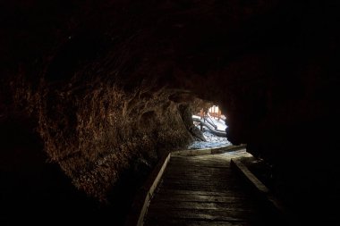 Kayalıklarda eski bir yarasa mağarası. Turist eğlencesi. Mağaraya gir.