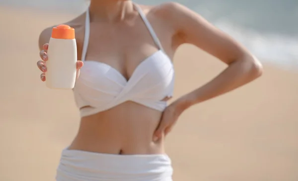 Жінка Білому Бікіні Тримає Сонцезахисну Пляшку Руці Пляжі — стокове фото
