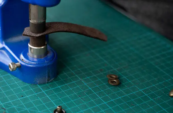 工匠们用手压的方法把皮夹放在皮夹里做成皮夹 手压推拉机是皮革厂的工匠使用的工具 — 图库照片