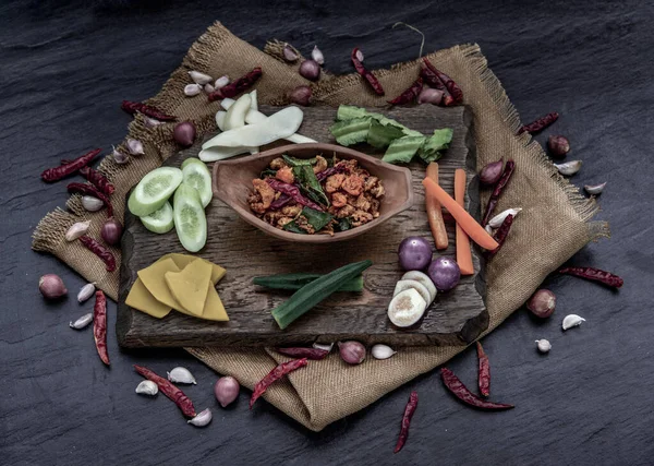 豚肉クラッキングチリ揚げカフィールライムの葉と材料と新鮮な野菜を木の背景に貼り付ける — ストック写真