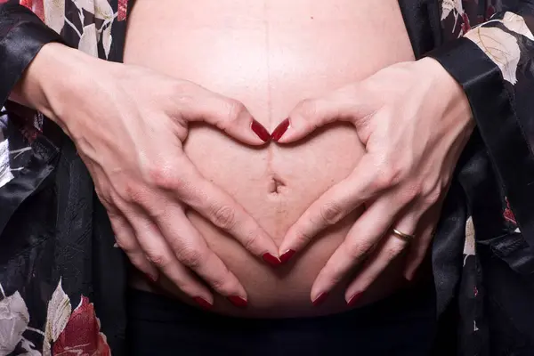 Ruce Tvořící Srdce Břiše Těhotné Ženy Studio Natáčení — Stock fotografie