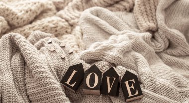 Cozy composition with knitted elements and wooden decorative word love.