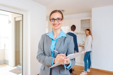 Yeni evde emlakçı. Arka planda bir çift var.