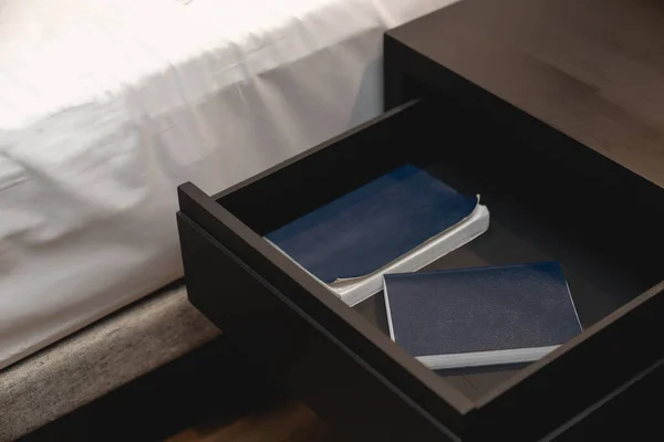 ホワイトシートと木製の引き出しスタンドとノートブックの横にベッド内側 — ストック写真
