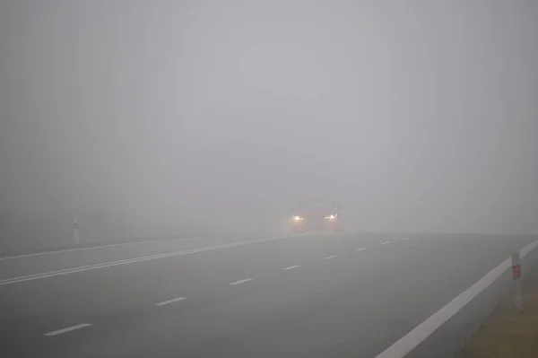 霧の中で車 悪天候や道路上の危険な自動車交通 霧の中の軽自動車 — ストック写真