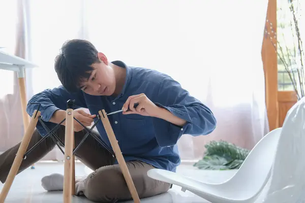 若い男はDiyの仕事をし 自宅で家具を組み立てる — ストック写真
