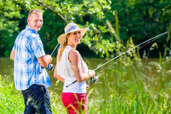 若いカップル釣りや川の岸に立っているを釣り — ストック写真