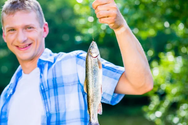 釣り竿にぶらさがるキャッチを示すスポーツ漁師 — ストック写真