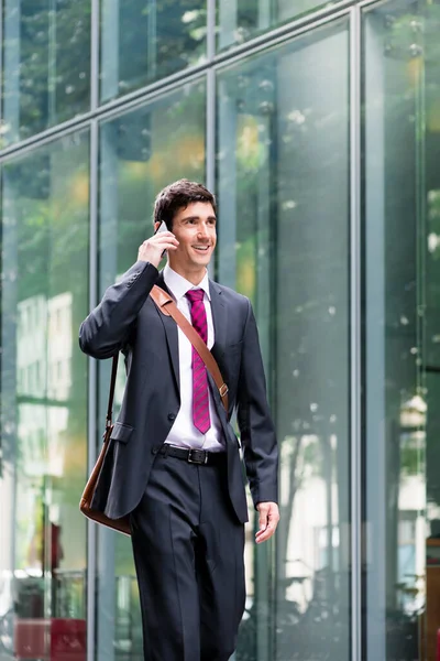 Szczęśliwy Młody Człowiek Garniturze Biznesowym Podczas Rozmowy Przez Telefon Komórkowy — Zdjęcie stockowe