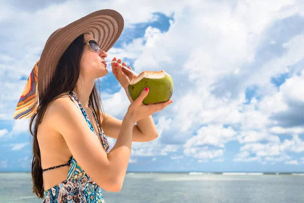 假日在海滩喝椰子奶的女游客 — 图库照片