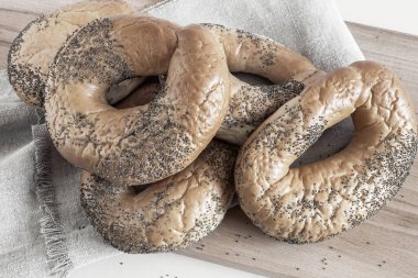 Kesme tahtasında haşhaş tohumlu simit.