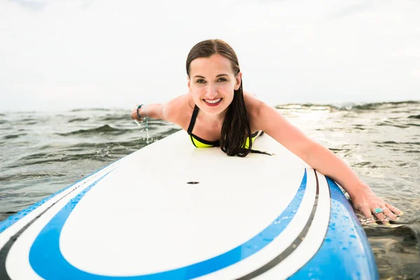 女性サーファーのサーフボードに開いて海のパドリング — ストック写真
