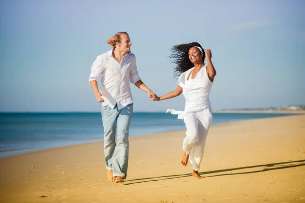 多样性对夫妇行走和奔跑在海滩上 — 图库照片