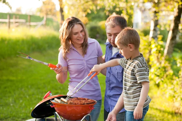 Bahçelerinde barbekü yapan bir aile.  