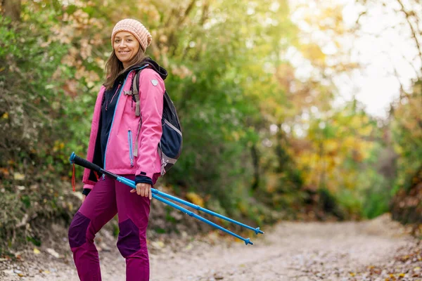 远足的女孩站在高山上宽阔的小径上 背包客在森林里穿着粉色夹克室外健康的健身生活方式 — 图库照片