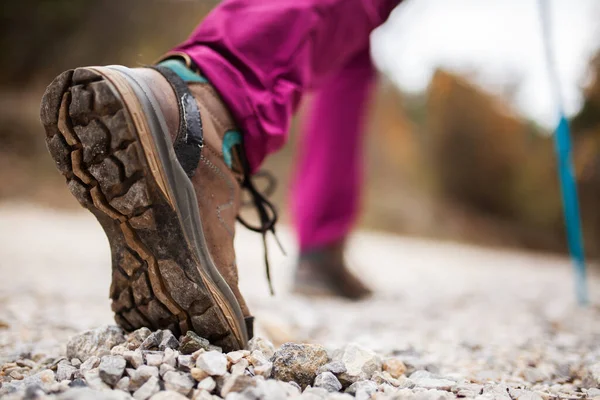 自然の中でハイキングの女の子 小石未舗装道路上の一般的なスポーツシューズや足の低角度ビュー 健康的なフィットネスライフスタイル屋外 — ストック写真