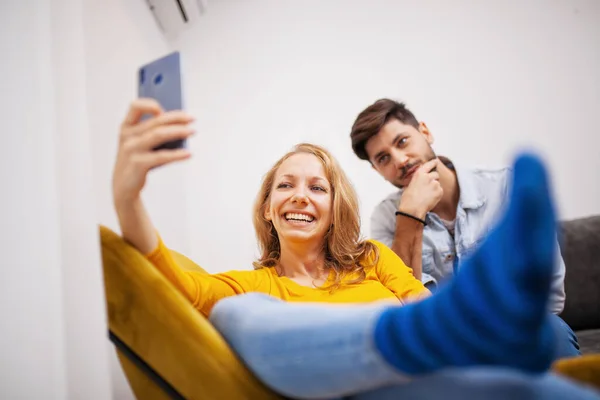 happy young couple with mobile phone taking selfie