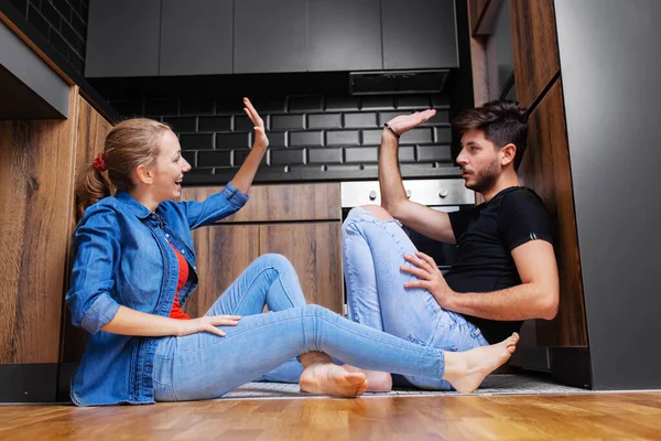 Couple Giving High Five Sitting Floor Modern Kitchen — Stock Photo, Image