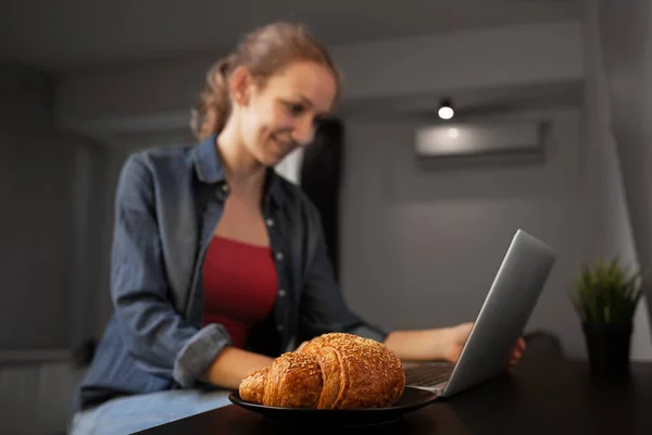 Děvče Pracující Doma Laptopu Zaměření Croissant — Stock fotografie