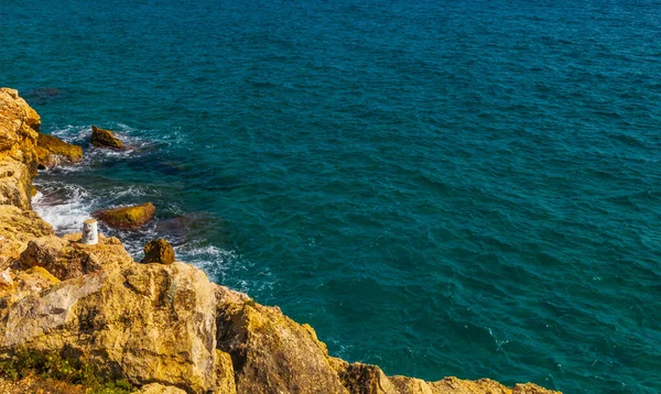 海の上の高い崖夏の海の背景多くの水しぶき波と石 — ストック写真