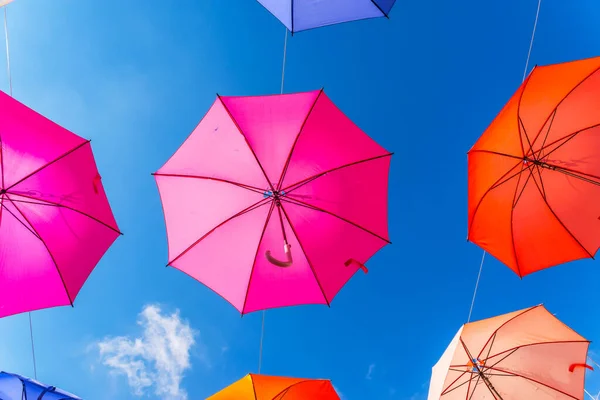 五彩斑斓的雨伞城市街道装饰 在蓝天上挂着五彩缤纷的雨伞 还有旅游景点 — 图库照片