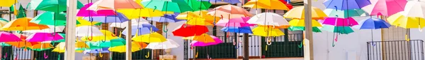 五彩斑斓的雨伞城市街道装饰 在蓝天上挂着五彩缤纷的雨伞 还有旅游景点 — 图库照片