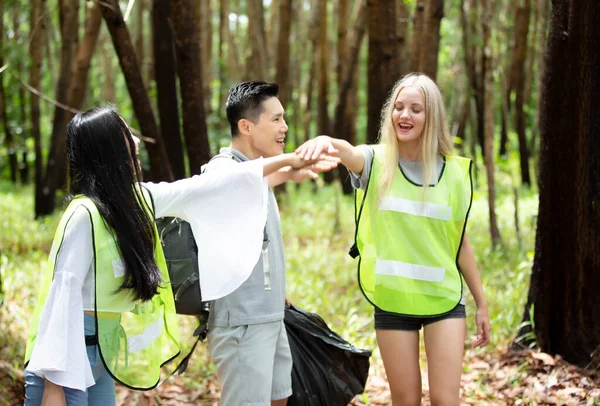 緑のボランティア ゴミ袋を持っていて 公園でゴミを拾うのを助ける楽観的な2人のボランティア 彼らはゴミを拾い 黒いゴミ袋に入れています 生態保護の概念 — ストック写真