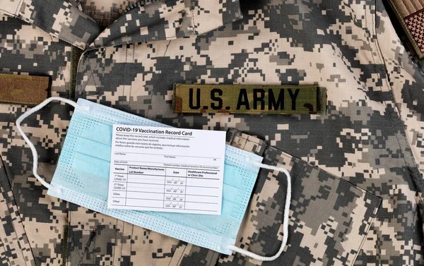 米陸軍の制服に関するCovid 19ワクチン接種記録カードと個人的フェイスマスク — ストック写真