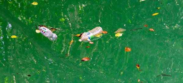 水に浮かんでいる間のボトル入りの水は環境を汚染する — ストック写真