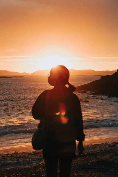 フェイスマスク ウェルネスコンセプト 人生と自由を身に着けているビーチでカラフルな夕日の前の旅行者 — ストック写真