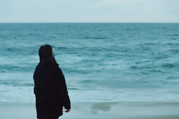 巨大な海の前のカメラに背を向けてコピースペースを持つ女性 — ストック写真