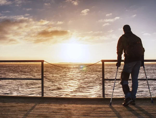 男ハイカーは太陽に海の上の波止場のスパイの上を歩く 幻想的な朝 — ストック写真