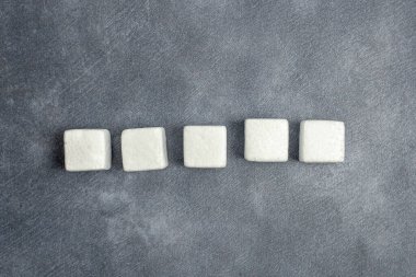 Koyu taştan bir zemin üzerinde beyaz kare küpler