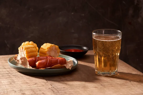 木製のテーブルのグリル ソーセージとおいしいビールのグラス — ストック写真