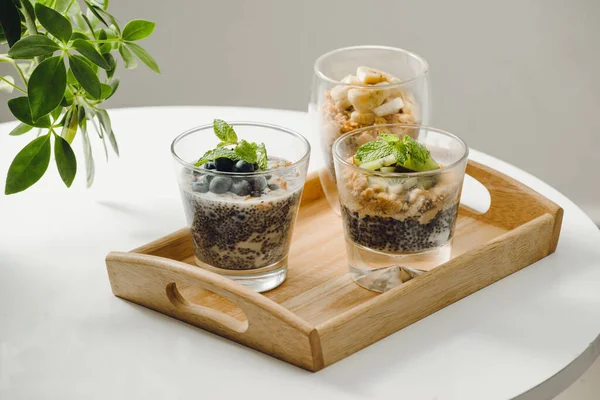 木製のテーブルの健康的な朝食のグラノーラとチアの種子とフルーツ ヨーグルトのパルフェ — ストック写真