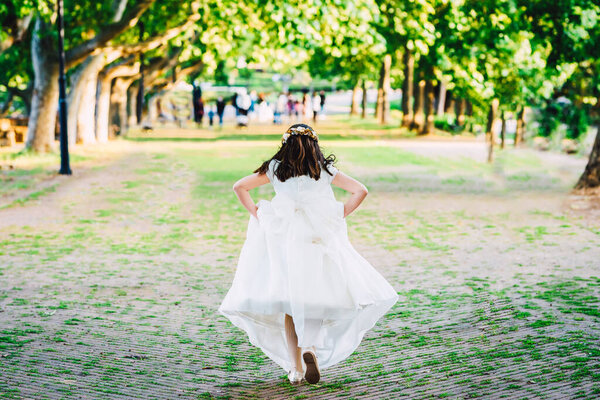 Girl in communion dress Running on the park