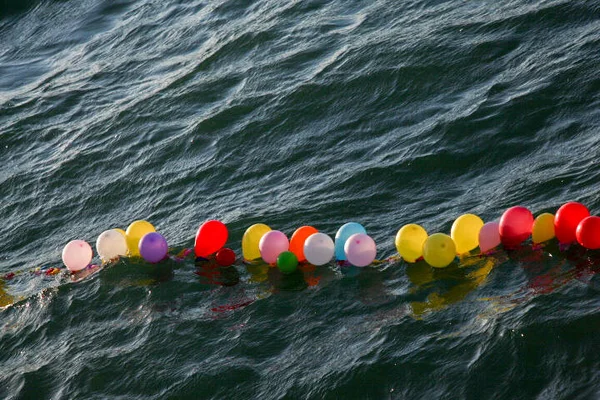 Balloons on a string for shooting game on water
