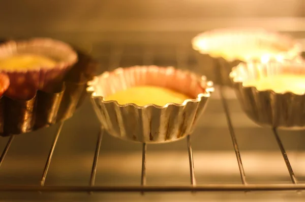 オーブンで型に自家製の甘いマフィンベーキング — ストック写真