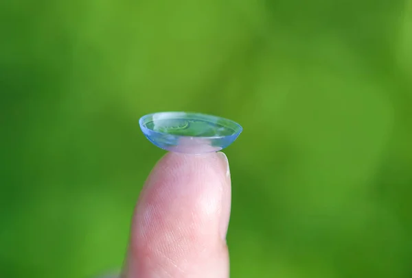 Transparente Kontaktlinse Der Fingerspitze Auf Verschwommenem Grünen Sommer Natur Hintergrund — Stockfoto