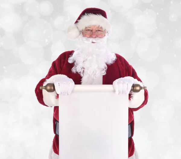 圣诞老人在他的身体前面拿着一卷纸 盖在雪白的背景上 这张纸是空白的 有复制的余地 — 图库照片