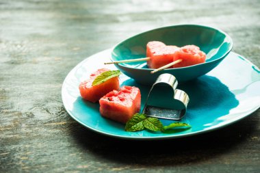 Arka plan için masa üstünde kalp şeklinde taze organik karpuz parçaları.