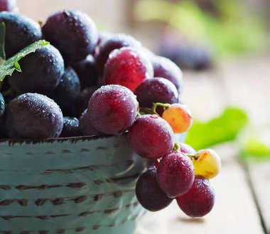 fresh red grapes in basket on rustic wooden table.