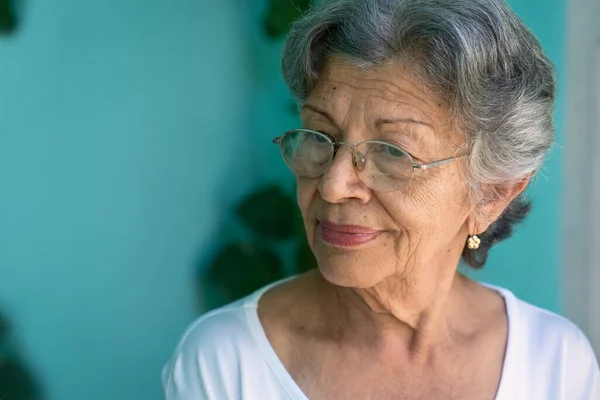 Elder woman in glasses on blue