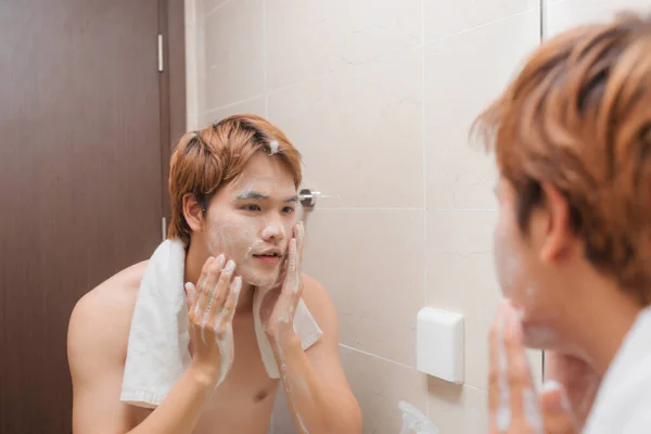 ハンサムな男性が浴室で顔を洗う — ストック写真