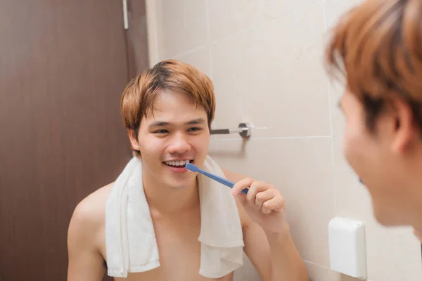 ハンサムな男ブラッシング彼の歯で朝バスルームで — ストック写真