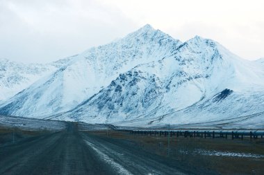 Dalton karayolu manzarası, karlı dağlar ve mavi gökyüzü