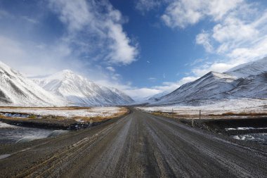Dalton karayolu manzarası, karlı dağlar ve mavi gökyüzü