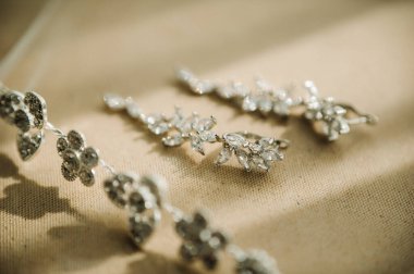 Gelin için aksesuarlar. Küpe ve bilezik. Beyaz alyanslar.