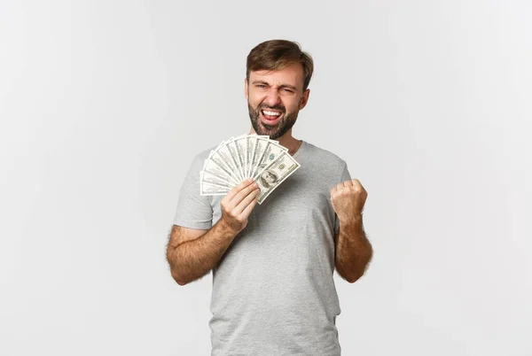Удовлетворенный Улыбающийся Мужчина Бородой Серой Футболке Радующийся Выигрывающий Деньги Держащий — стоковое фото